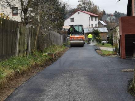 Zdjęcie przedstawia remontowaną drogę oraz walec wałujacy warstwę nawierzchnią drogi.